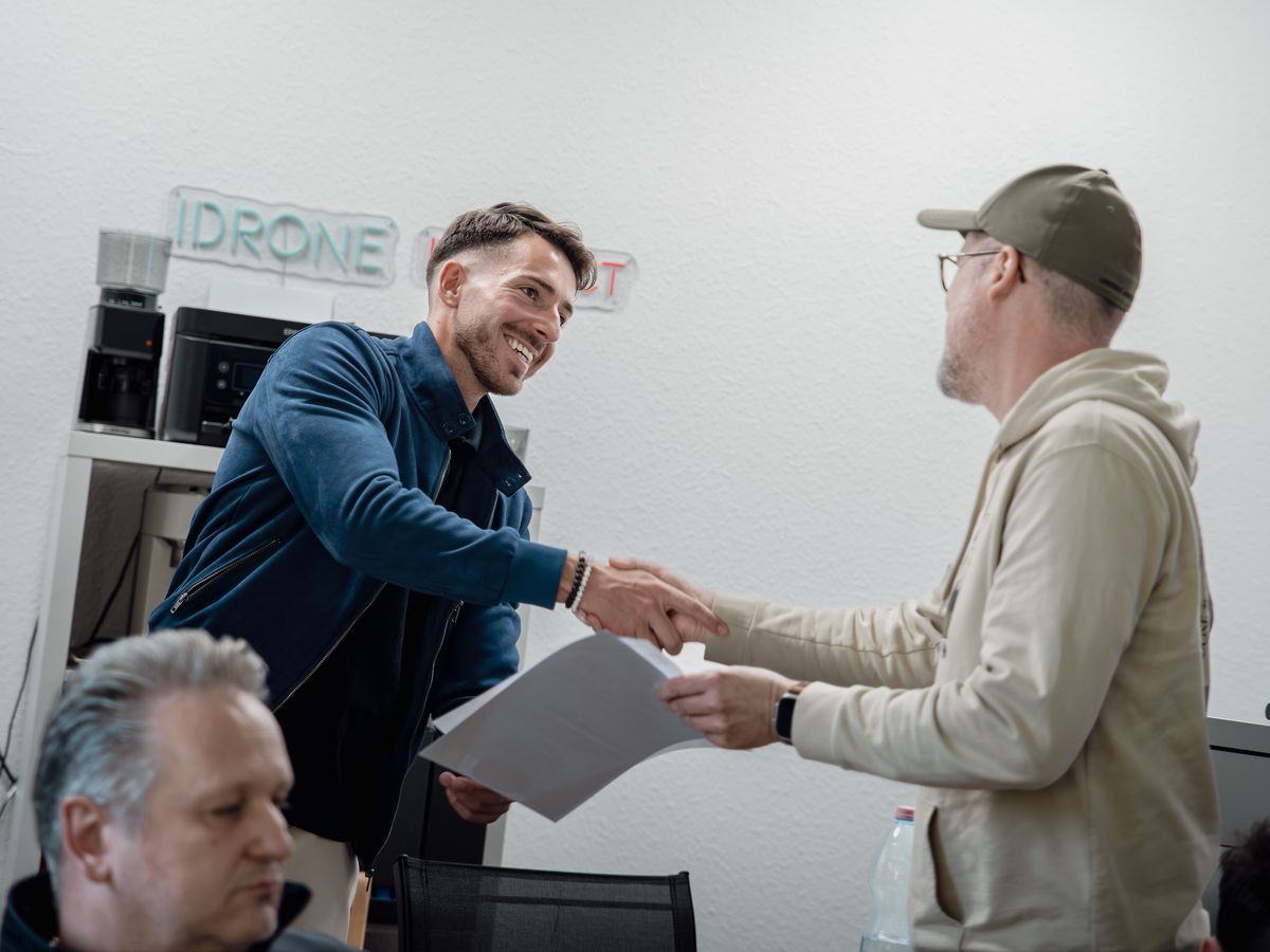 Oktató kézfogással adja át a tanúsítványt egy résztvevőnek